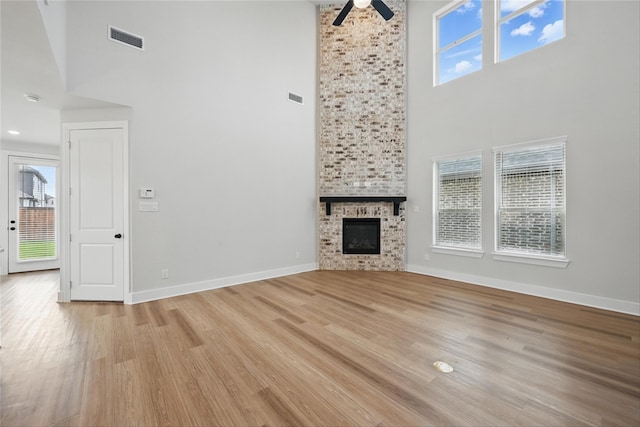 1851 Rosedale Ave, Van Alstyne, TX 75495 - unfurnished living room featuring light wood finished floors, a ceiling fan, a high ceiling, visible vents, and baseboards