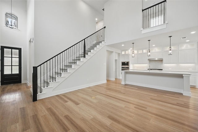 1851 Rosedale Ave, Van Alstyne, TX 75495 - unfurnished living room featuring stairway, a towering ceiling, light wood-type flooring, and recessed lighting