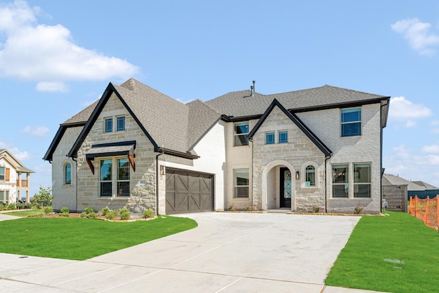 801 Daisy Corner Dr, Little Elm, TX 76227 - french country style house with stone siding, concrete driveway, a shingled roof, and an attached garage