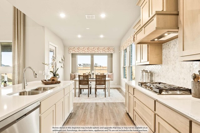 kitchen featuring visible vents, light wood-style floors, light countertops, a sink, and appliances with stainless steel finishes