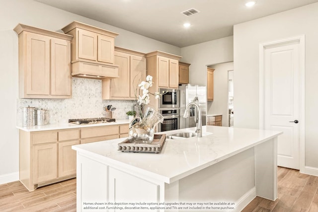 kitchen featuring backsplash, visible vents, appliances with stainless steel finishes, light wood-style floors, and light brown cabinets
