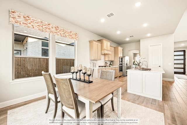 dining area with baseboards, visible vents, and light wood-style flooring