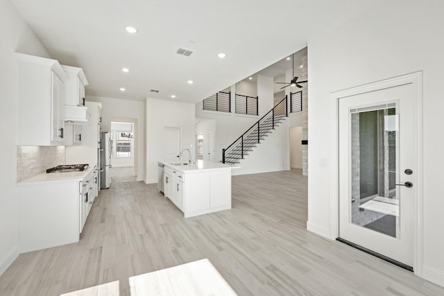 801 Daisy Corner Dr, Little Elm, TX 76227 - kitchen with a sink, appliances with stainless steel finishes, custom range hood, white cabinets, and light countertops