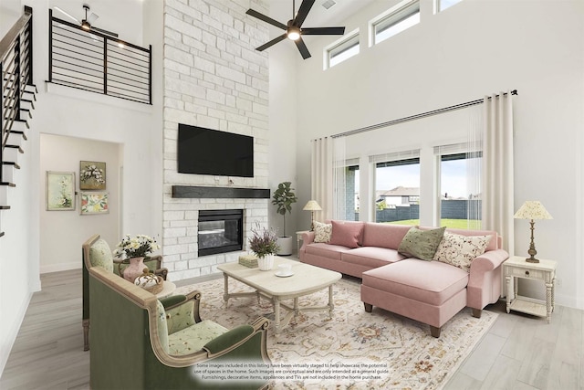 801 Daisy Corner Dr, Little Elm, TX 76227 - living area with a towering ceiling, ceiling fan, baseboards, a fireplace, and wood finished floors