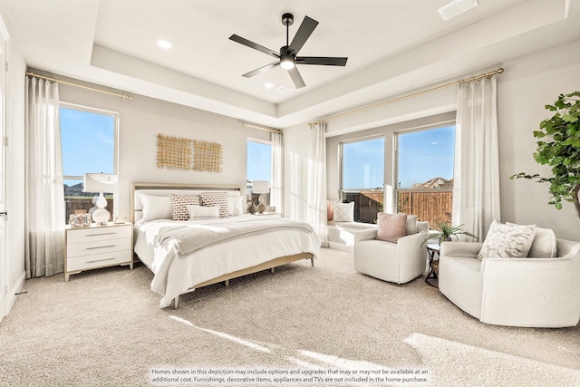 carpeted bedroom with a raised ceiling, a ceiling fan, recessed lighting, and visible vents
