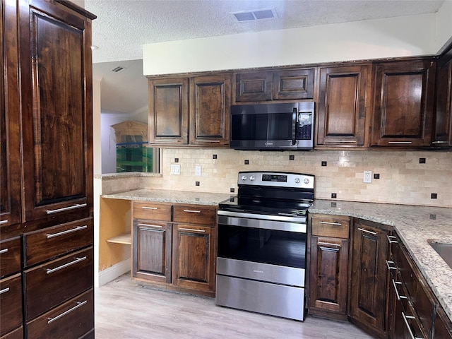 1005 Bass Dr, Plano, TX 75025 - kitchen featuring visible vents, dark brown cabinets, a textured ceiling, light wood finished floors, and stainless steel appliances