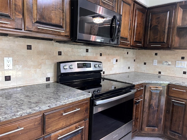 1005 Bass Dr, Plano, TX 75025 - kitchen featuring appliances with stainless steel finishes, tasteful backsplash, light stone countertops, and dark brown cabinets