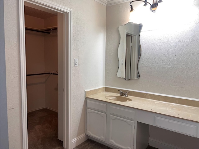 1005 Bass Dr, Plano, TX 75025 - bathroom with vanity, a textured wall, and a walk in closet