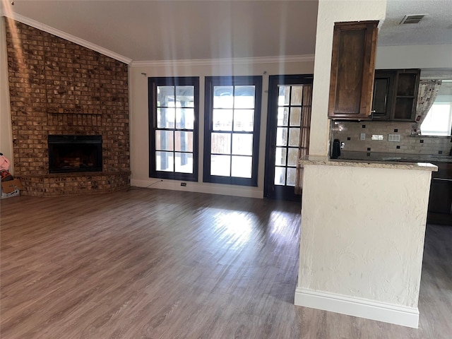 1005 Bass Dr, Plano, TX 75025 - kitchen with backsplash, visible vents, a brick fireplace, wood finished floors, and open floor plan