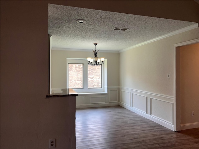1005 Bass Dr, Plano, TX 75025 - empty room with visible vents, crown molding, wood finished floors, and a chandelier