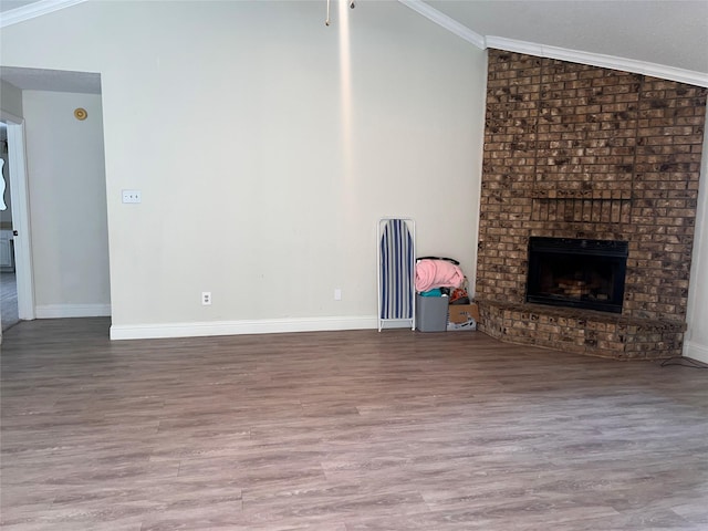 1005 Bass Dr, Plano, TX 75025 - unfurnished living room featuring ornamental molding, a brick fireplace, wood finished floors, baseboards, and vaulted ceiling
