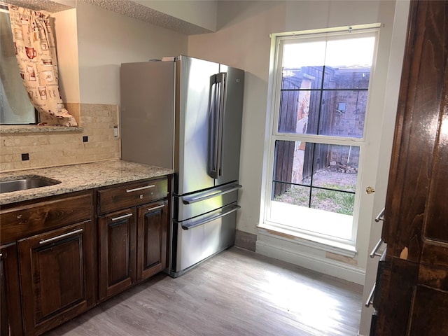 1005 Bass Dr, Plano, TX 75025 - kitchen with freestanding refrigerator, baseboards, dark brown cabinetry, and light wood-style flooring
