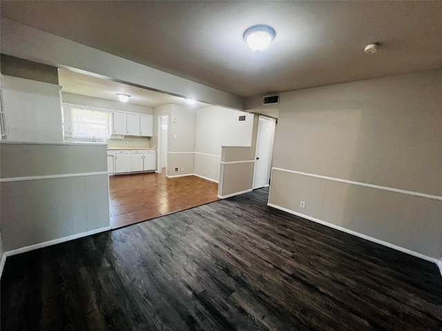 interior space featuring baseboards, visible vents, and dark wood-type flooring