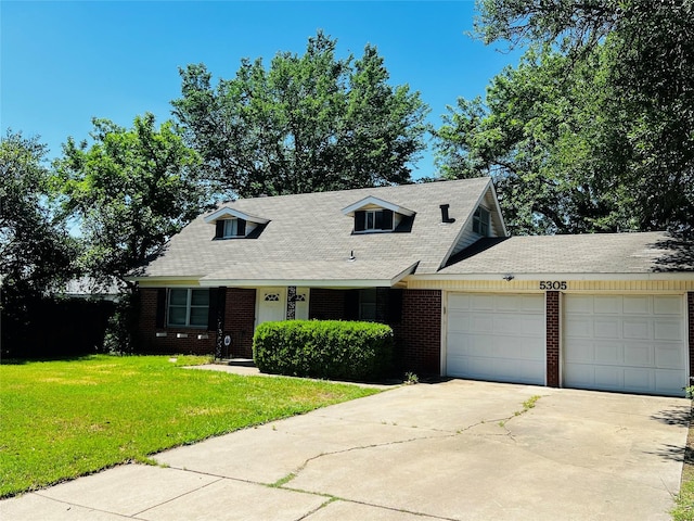 cape cod-style house with brick siding, a garage, a front yard, and concrete driveway