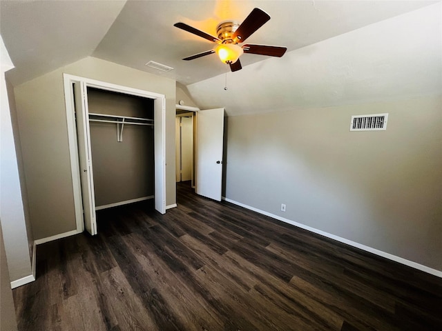 unfurnished bedroom featuring baseboards, lofted ceiling, dark wood-style flooring, and visible vents