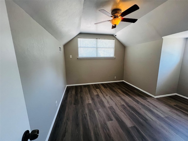 bonus room with ceiling fan, baseboards, vaulted ceiling, dark wood-type flooring, and visible vents
