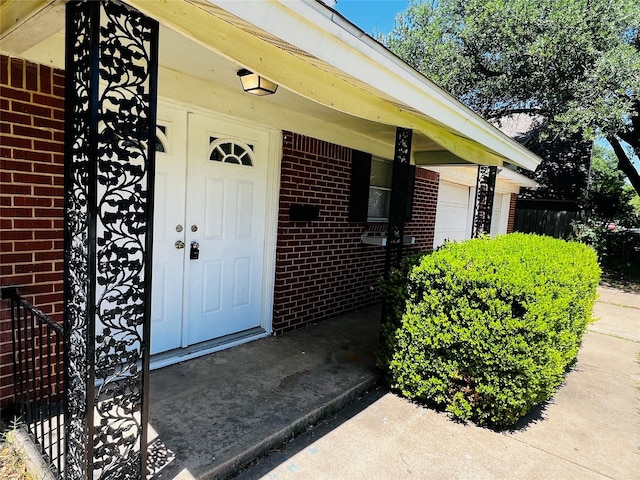 view of exterior entry featuring brick siding
