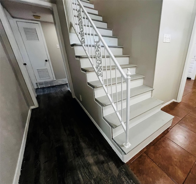 stairs featuring baseboards, visible vents, and tile patterned flooring