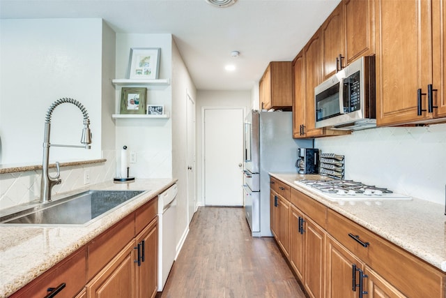 1200 Ridgeway Dr, Richardson, TX 75080 - kitchen featuring brown cabinets, appliances with stainless steel finishes, decorative backsplash, and a sink