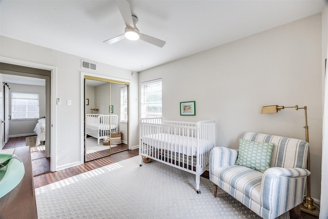 1200 Ridgeway Dr, Richardson, TX 75080 - bedroom featuring a ceiling fan, visible vents, wood finished floors, baseboards, and a closet