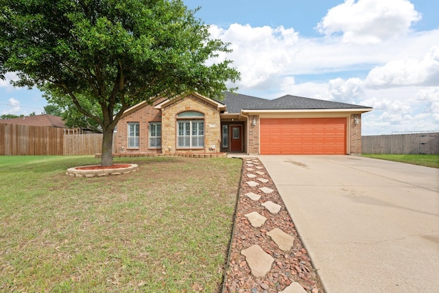 single story home featuring fence, an attached garage, a front lawn, brick siding, and concrete driveway