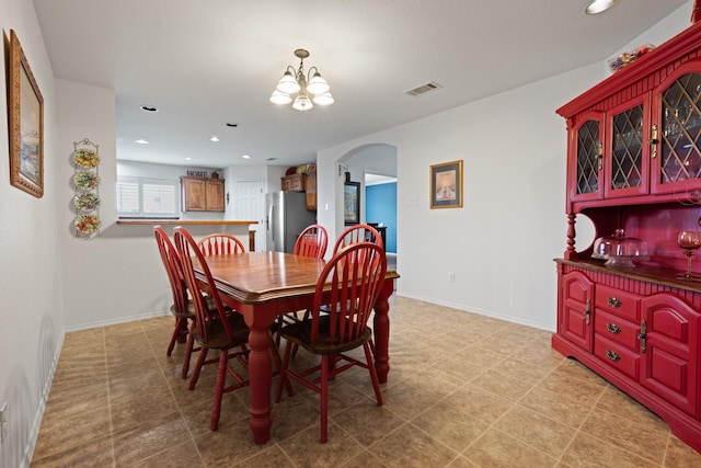 dining area with arched walkways, a notable chandelier, visible vents, and recessed lighting