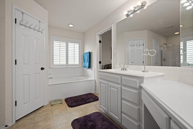 bathroom with vanity, a wealth of natural light, a garden tub, and a stall shower