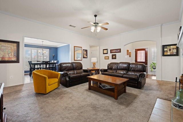 carpeted living area featuring arched walkways, ceiling fan, ornamental molding, and visible vents