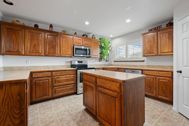 kitchen with recessed lighting, light countertops, a center island, a sink, and appliances with stainless steel finishes