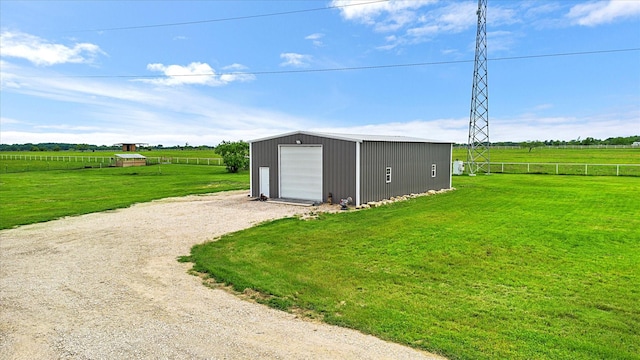 view of outdoor structure with fence, dirt driveway, an outbuilding, and a rural view