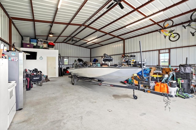 garage featuring freestanding refrigerator and metal wall