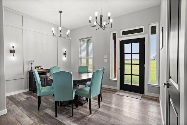 dining area featuring baseboards, a chandelier, and wood finished floors