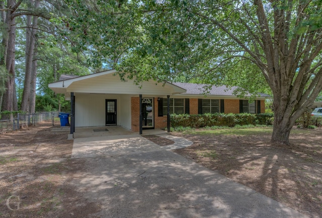 ranch-style home featuring fence, an attached carport, driveway, and brick siding