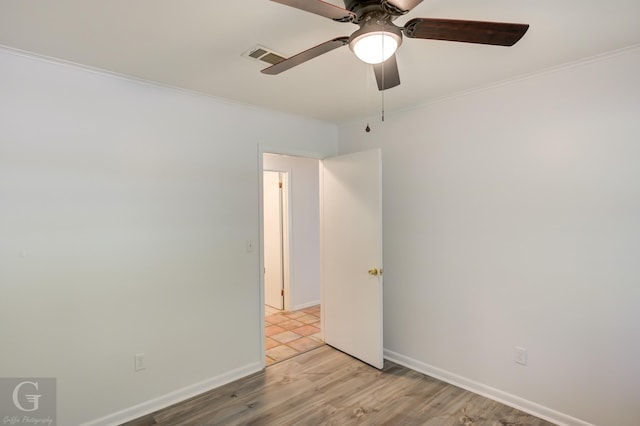 unfurnished room with visible vents, ornamental molding, baseboards, light wood-type flooring, and a ceiling fan