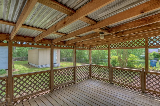 wooden terrace featuring an outdoor structure, a yard, and a shed
