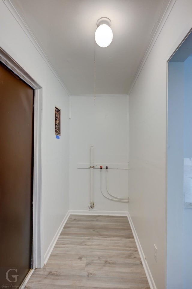 interior space featuring crown molding, light wood finished floors, and baseboards