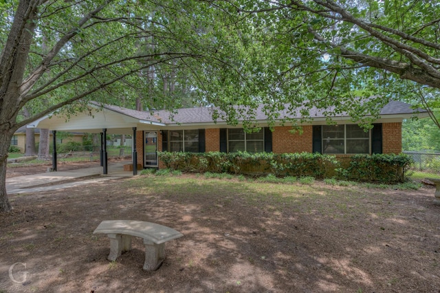 ranch-style home featuring brick siding and fence