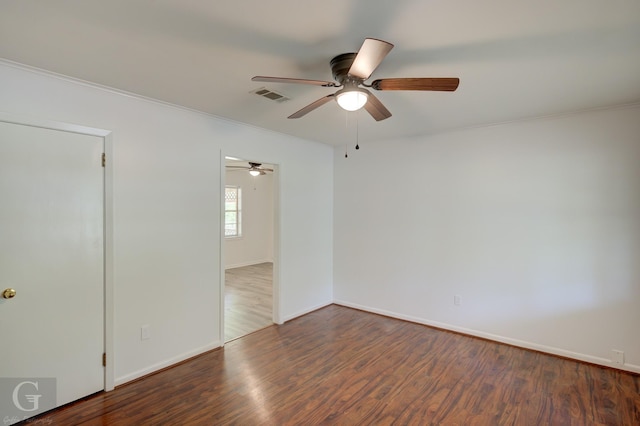 spare room with baseboards, ceiling fan, visible vents, and wood finished floors