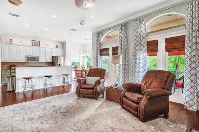 3906 Sharp Ln, Richardson, TX 75082 - living area with crown molding, wood-type flooring, visible vents, and a healthy amount of sunlight