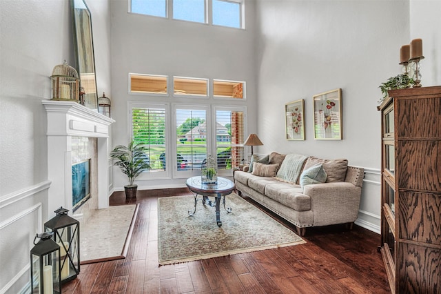 3906 Sharp Ln, Richardson, TX 75082 - living area featuring a premium fireplace, baseboards, dark wood-style flooring, and a towering ceiling