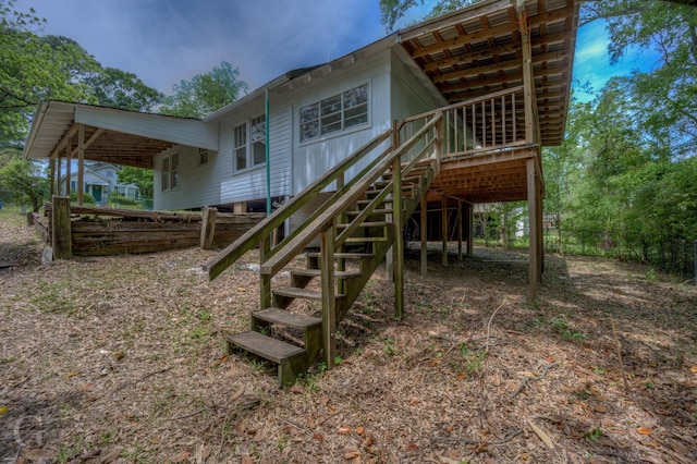 rear view of house with fence, a deck, and stairway