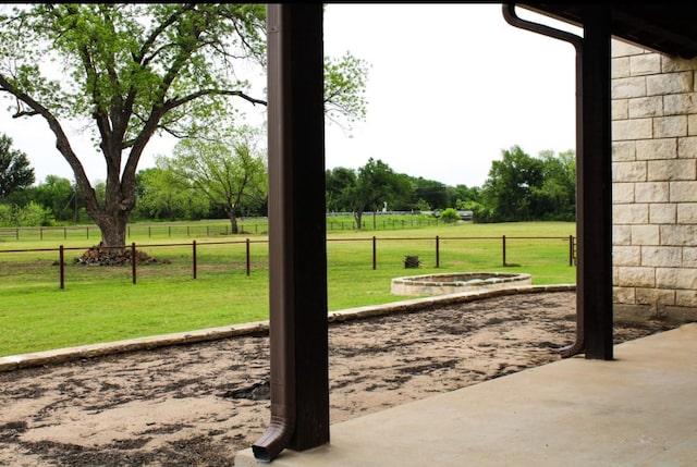 exterior space featuring a lawn, fence, and a rural view