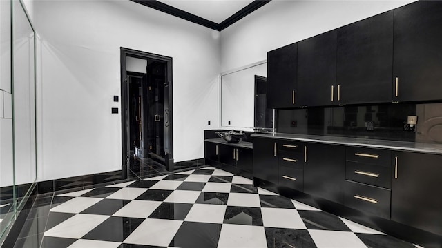 kitchen with dark cabinets, light countertops, and ornamental molding