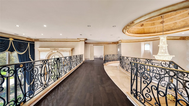 corridor featuring ornamental molding, recessed lighting, wood finished floors, and an upstairs landing