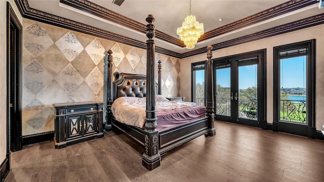 bedroom with dark wood-style flooring, access to outside, a notable chandelier, a tray ceiling, and ornamental molding