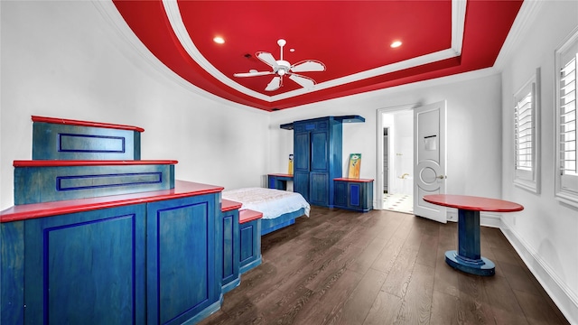 bedroom with a ceiling fan, dark wood finished floors, a raised ceiling, baseboards, and ornamental molding
