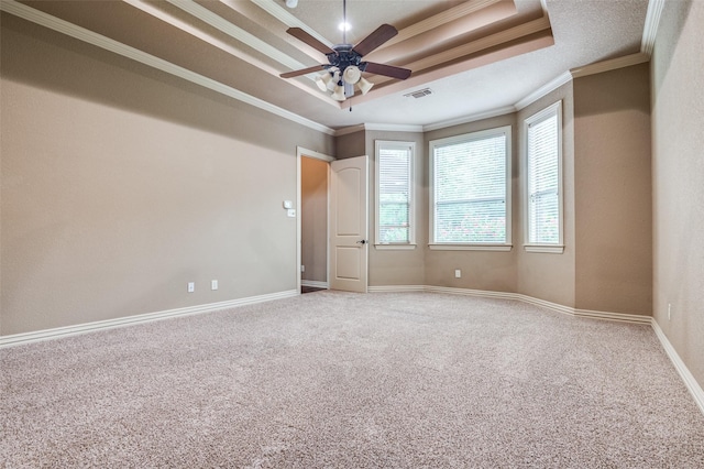 unfurnished room with visible vents, ornamental molding, carpet, and a tray ceiling