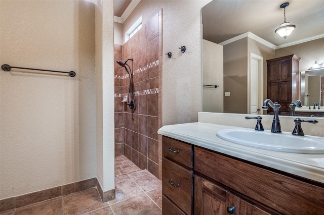 bathroom with vanity, ornamental molding, a textured wall, and tiled shower