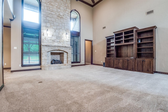 unfurnished living room with a high ceiling, baseboards, and carpet