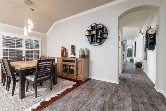 dining space featuring dark wood-style flooring, visible vents, crown molding, arched walkways, and lofted ceiling